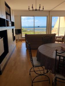 a living room with a table and a view of the ocean at Vue Mer Santa Clara 3 in La Baule
