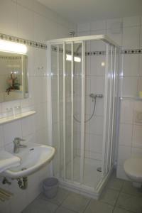 uma casa de banho com um chuveiro e um lavatório. em Gästehaus Elisabeth em Schwangau