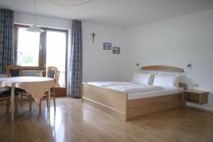 1 dormitorio con cama, mesa y comedor en Gästehaus Elisabeth, en Schwangau