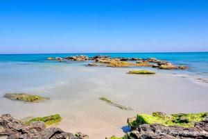 a sandy beach with rocks in the ocean at Meraviglia d'Otranto in Otranto