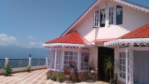 a house with a red roof and a balcony at Yashita Homestay in Darjeeling