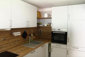 a kitchen with white cabinets and a sink at Waldblick in Obertal
