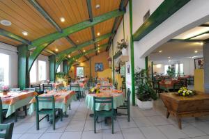 una sala da pranzo con tavoli, sedie e soffitti in legno di LOGIS Hôtel Le Moulin Des Gardelles a Riom