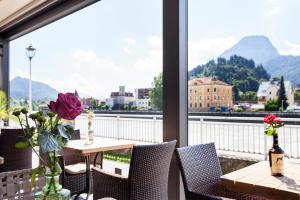 einen Balkon mit einem Tisch und Stühlen sowie einem großen Fenster in der Unterkunft Boutique Hotel im Auracher Löchl in Kufstein