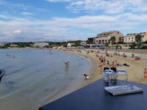 a beach with a bunch of people in the water at La Petite Maison De Melanie 30m mer in Six-Fours-les-Plages