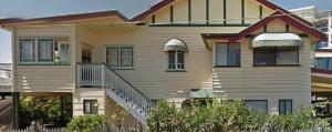 a large house with a staircase in front of it at Beachside Queenslander in Scarborough