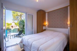 a bedroom with a large bed and a balcony at T3 Rez de Jardin,Piscine Privée in Saint-Cyr-sur-Mer