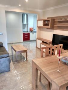 een woonkamer met houten tafels en een keuken bij Bonito apartamento in Torre del Mar