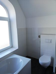 La salle de bains blanche est pourvue de toilettes et d'un lavabo. dans l'établissement Holsteiner Hof, à Heist