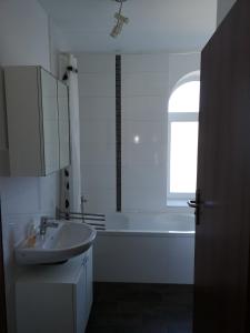 La salle de bains est pourvue d'un lavabo, d'une baignoire et d'une fenêtre. dans l'établissement Holsteiner Hof, à Heist