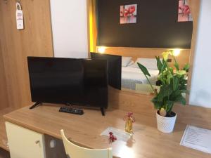 a desk with a television on top of a room at Hotel Ayri in Medesano