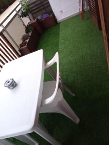 einen weißen Stuhl auf einem Balkon mit grünem Gras in der Unterkunft APARTAMENTO EN LA PLAYA in Miami Platja