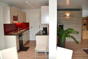 a kitchen with white cabinets and a table and chairs at FeWo Müller-Bläuer in Gersau