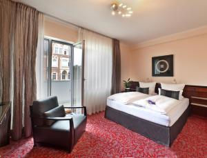 Pokój hotelowy z łóżkiem i krzesłem w obiekcie Top Hotel Krämer w Koblencji
