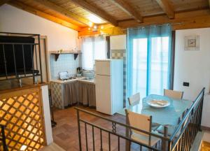 een keuken met een tafel en een witte koelkast bij La casetta in Terrasini