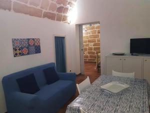 een woonkamer met een blauwe stoel en een tafel bij La casetta in Terrasini