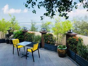 eine Terrasse mit einem Tisch, Stühlen und Pflanzen in der Unterkunft Pontian Garden Hotel in Pontian Kecil