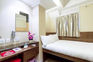 1 dormitorio con cama y escritorio con espejo en Shanghai Red, en Hong Kong