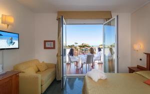 a living room with a couch and a sliding glass door at Hotel Residence Villa Marzia in Marina di Pietrasanta +36 photos