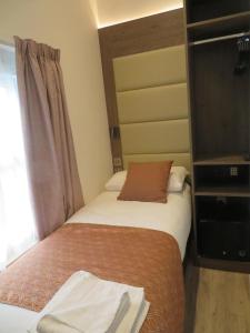 1 dormitorio con 2 camas, TV y ventana en Glendale Hyde Park Hotel, en Londres