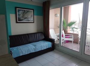 a living room with a couch and a balcony at Appartement Cap Hermès in Fréjus +91 photos