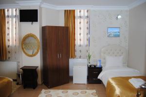 イスタンブールにあるロータス ホテルのベッドルーム(ベッド1台、キャビネット、テレビ付)