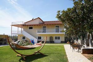 a hammock in a yard in front of a house at Eleni's Holiday Home in Kalamata