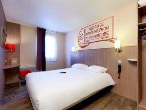 Postel nebo postele na pokoji v ubytování Brit Hotel Essentiel Cholet