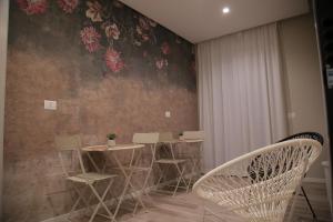 une salle à manger avec des chaises et un mur fleuri dans l'établissement B&b Antigua, à Altamura
