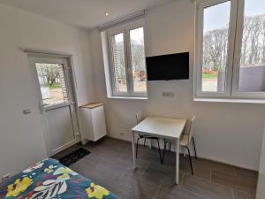 a bedroom with a desk and a bed and a tv at Manoir des Carreaux in Ingouville