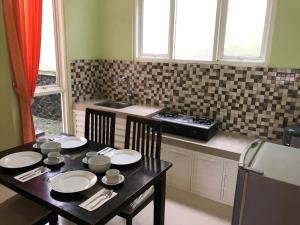 a kitchen with a table with chairs and a sink at Villa Safira in Batu