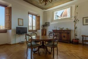 a dining room with a table and chairs and a tv at The Suite Dome Apartment by Mamo Florence in Florence