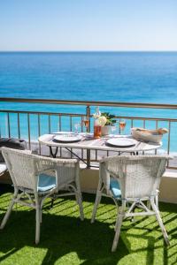 a table and chairs on a balcony with the ocean at Breathtaking sea view, 2 terraces and A/C in Nice