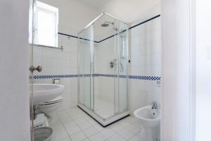 La salle de bains est pourvue d'une douche, d'un lavabo et de toilettes. dans l'établissement Hotel Baia Di Puolo, à Massa Lubrense