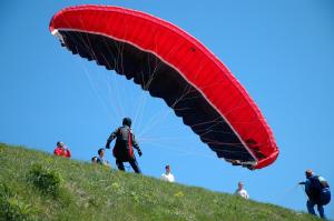 a person flying a red parachute on a hill at Apartments Slap in Slappe dʼIdria