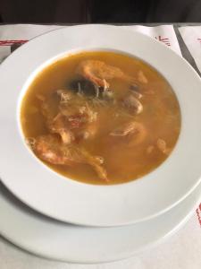 un tazón de sopa de pollo en un plato blanco en Hostal Restaurante Taibilla, en Nerpio