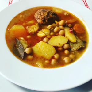 a bowl of soup on a white plate at Hostal Restaurante Taibilla in Nerpio