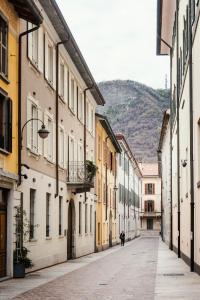 a person walking down a street with buildings at Giovio Loft - The House Of Travelers in Como