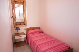 ein kleines Schlafzimmer mit einem Bett und einem Fenster in der Unterkunft Case Vacanza Renella 3 beds: Balcony, wifi, self-catering, 200mt from the sea in Sciacca