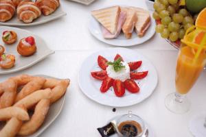 a white table topped with plates of food and fruit at Hotel Capizzo in Ischia