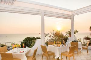 a dining room with a view of the ocean at Hotel Capizzo in Ischia