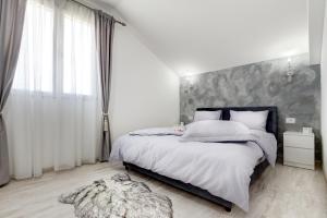 ein Schlafzimmer mit einem großen Bett mit einer grauen Wand in der Unterkunft Sunny Nest Apartments in Kotor