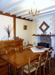 a dining room with a wooden table and a fireplace at Welcome in Authuille