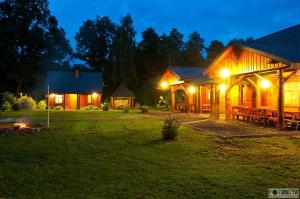 a night view of a cabin with tables and lights at Gajówka Sajczyce - gospodarstwo agroturystyczne in Chełm