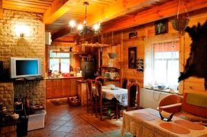 a kitchen with a table and a television in a room at Gajówka Sajczyce - gospodarstwo agroturystyczne in Chełm