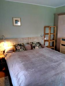 um quarto com uma cama grande e um cobertor cinzento em Lana em Nida
