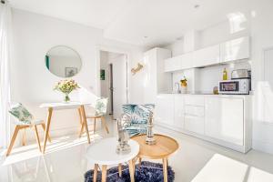 a kitchen with white cabinets and a table and chairs at NEW ! SEA VIEW Design + Balcony 203 in Villefranche-sur-Mer
