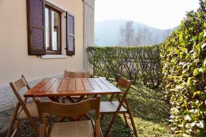 een houten tafel en stoelen op een terras bij Welcome Traveller LA PERLA APARTMENTS in Garda