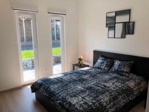 een slaapkamer met een bed en twee glazen schuifdeuren bij Ô Spa Ren in Spa
