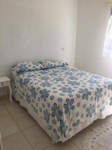 Vila Formosa Rural في ساو بيدرو: غرفة نوم بسرير وبطانية زرقاء وبيضاء